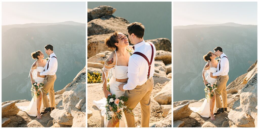 A couple smiles and shares a kiss on the rocky cliffs of Taft Point during their Yosemite elopement, with the valley views stretching out behind them.