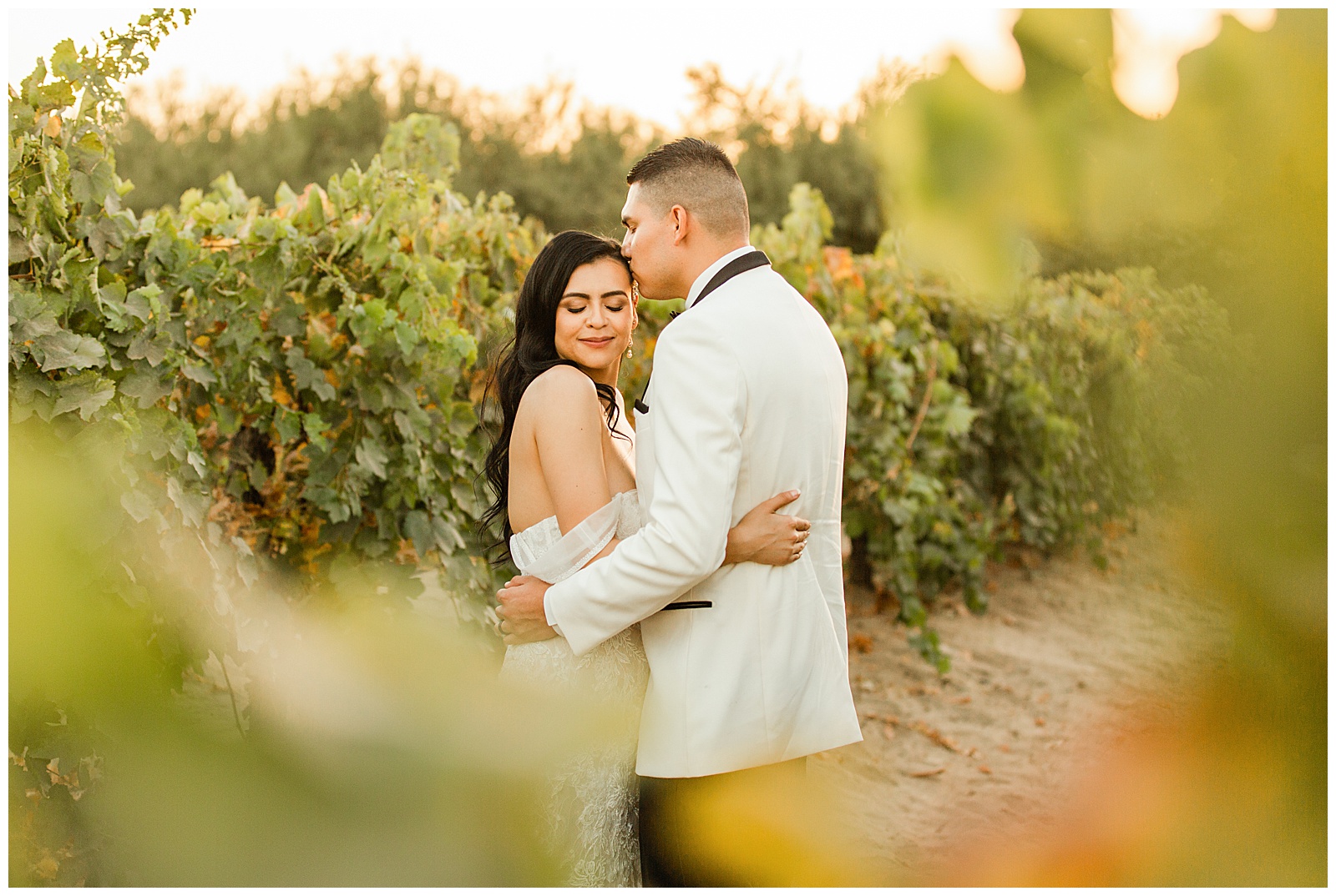 bride and groom embracing in a vineyard during sunset at r wedding and events, the ranch, selma