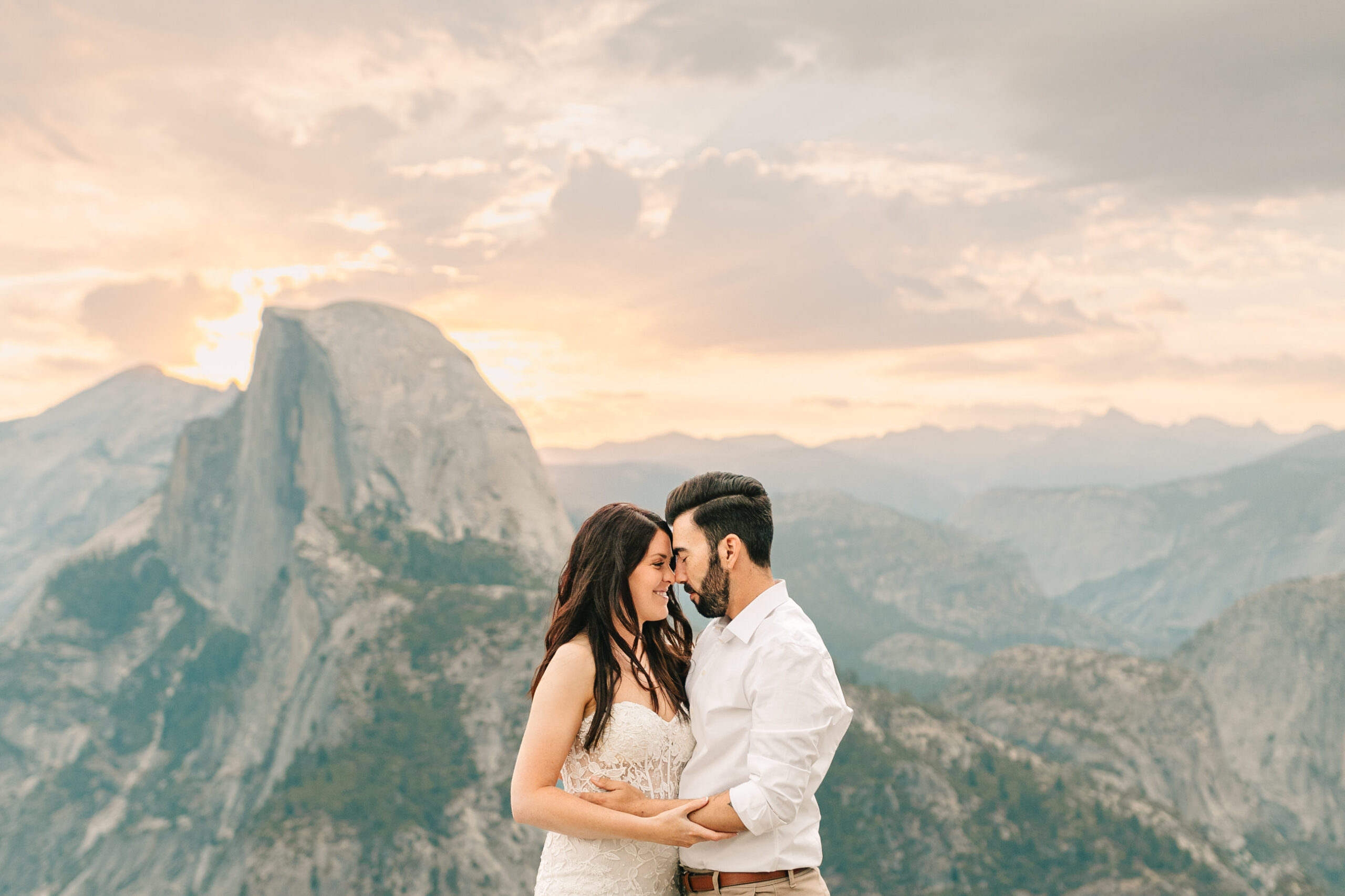 Bride and Groom in a close embrace during sunrise at Glacier Point on their wedding day