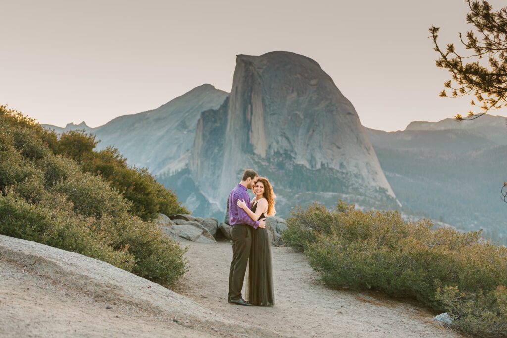 Engaged Couple snuggling at Glacier Point in Yosemite with Half-Dome in the background