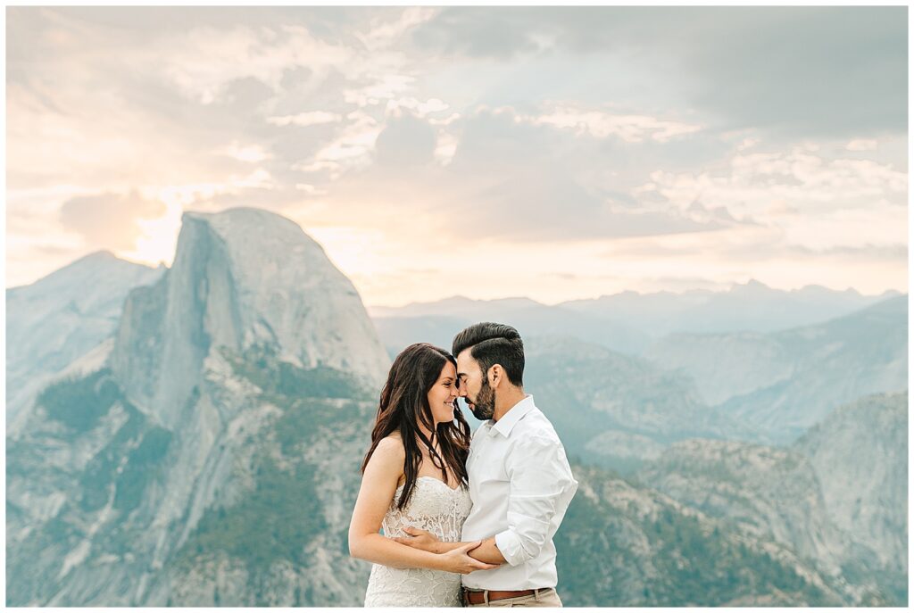 Couple sharing an intimate moment during their elopement with Half Dome in the background at sunrise