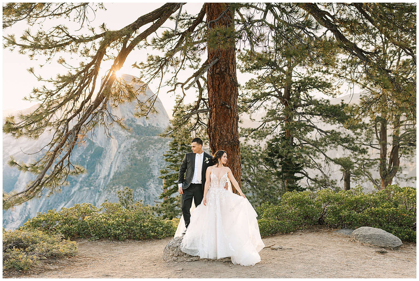 Bride and groom sharing an intimate moment under a tree with Half Dome in the background during their elopement