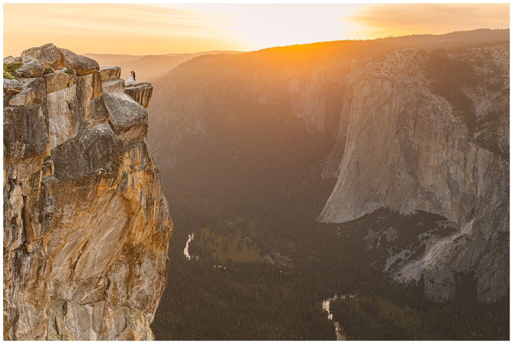 bride and groom standing at the edge of taft point during their yosemite elopement